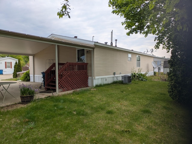 4153 Whisperwood Way S, Muskegon, MI 49442 - back of house with central air condition unit, a yard, and an attached carport
