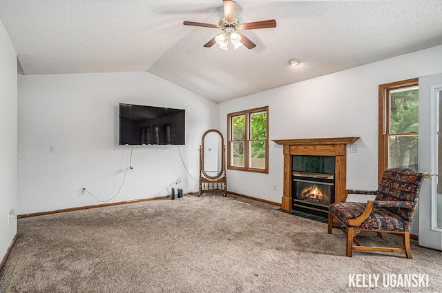 7460 Anthony St, Whitehall, MI 49461 - living room with carpet flooring, a ceiling fan, vaulted ceiling, baseboards, and a fireplace with flush hearth