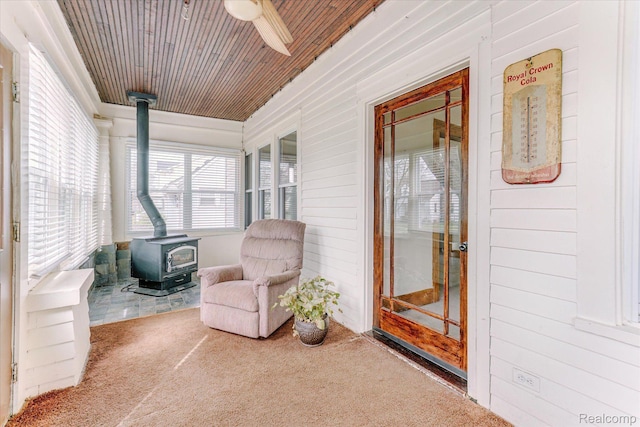 2210 Cambridge Rd, Berkley, MI 48072 - sunroom featuring a wood stove, carpet, wooden ceiling, and wooden walls