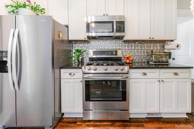 2210 Cambridge Rd, Berkley, MI 48072 - kitchen featuring stainless steel appliances, backsplash, dark wood-type flooring, and dark stone countertops