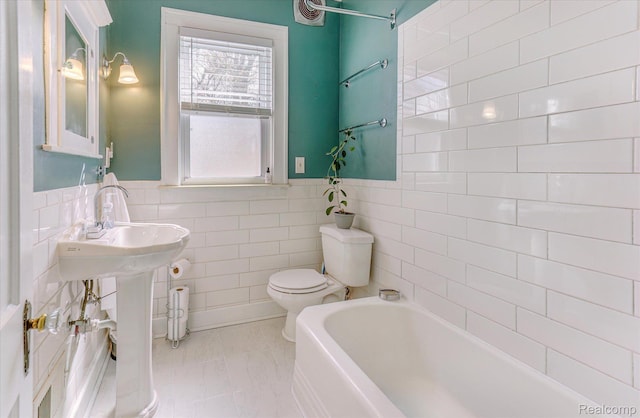 2210 Cambridge Rd, Berkley, MI 48072 - full bath featuring a bathtub, toilet, tile walls, and a wainscoted wall