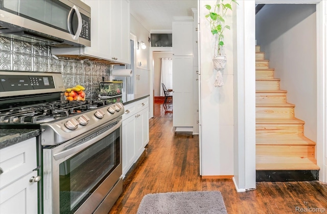 2210 Cambridge Rd, Berkley, MI 48072 - kitchen with appliances with stainless steel finishes, dark countertops, dark wood-style floors, white cabinets, and backsplash
