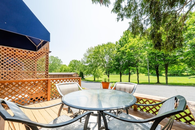 5576 N Watervliet Rd Unit 11, Watervliet, MI 49098 - wooden terrace with outdoor dining area, view of wooded area, and a yard