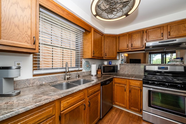 5576 N Watervliet Rd Unit 11, Watervliet, MI 49098 - kitchen featuring stainless steel appliances, a sink, brown cabinetry, wood finished floors, and light stone counters