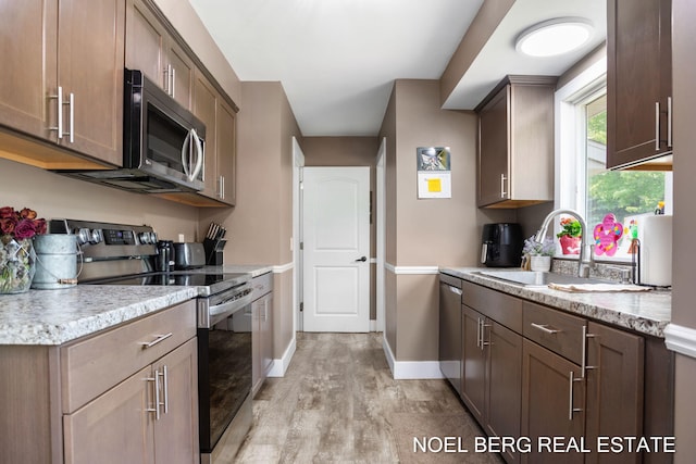 16507 Sleeper St, Grand Haven, MI 49417 - kitchen with appliances with stainless steel finishes, light wood-type flooring, a sink, and baseboards