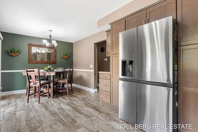 16507 Sleeper St, Grand Haven, MI 49417 - dining area with a chandelier, light wood-style floors, and baseboards