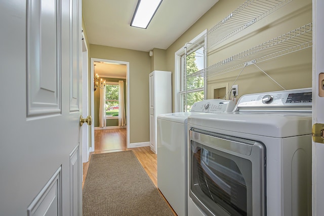 1196 Rathfon Cir, Saline, MI 48176 - laundry area with washer and dryer, light wood-type flooring, plenty of natural light, and a chandelier