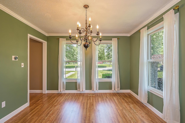 1196 Rathfon Cir, Saline, MI 48176 - unfurnished dining area with a chandelier, wood finished floors, baseboards, ornamental molding, and a textured ceiling