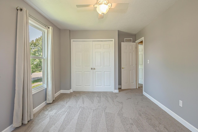 1196 Rathfon Cir, Saline, MI 48176 - unfurnished bedroom featuring carpet flooring, a closet, baseboards, a ceiling fan, and a textured ceiling