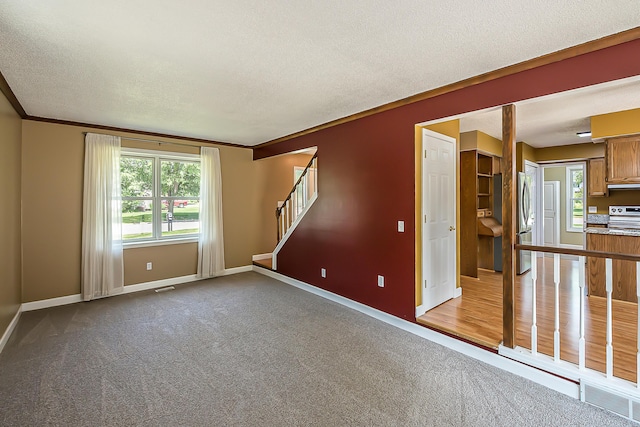1196 Rathfon Cir, Saline, MI 48176 - spare room with dark colored carpet, baseboards, stairs, a textured ceiling, and crown molding