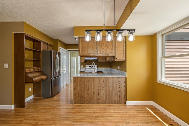 1196 Rathfon Cir, Saline, MI 48176 - kitchen with stainless steel appliances, a peninsula, light wood finished floors, light stone countertops, and a textured ceiling