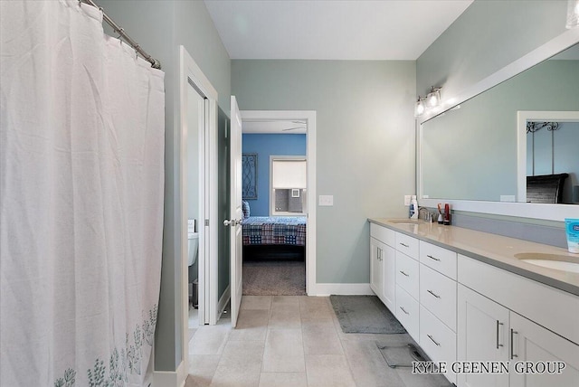4745 W Lake Dr, Holland, MI 49423 - ensuite bathroom with double vanity, toilet, baseboards, and tile patterned flooring
