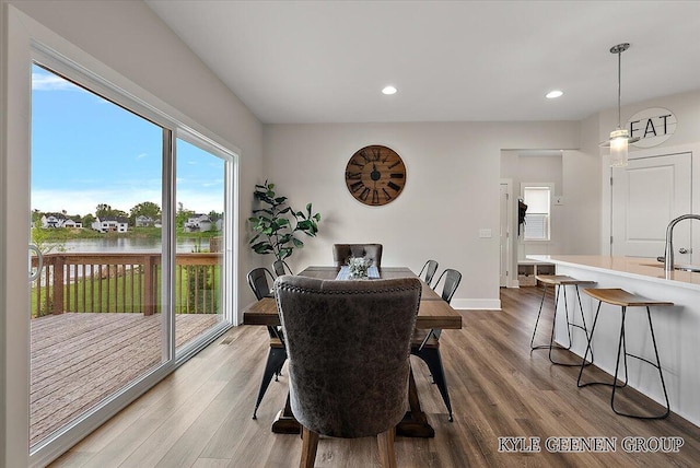 4745 W Lake Dr, Holland, MI 49423 - dining space with wood finished floors, a water view, recessed lighting, and baseboards