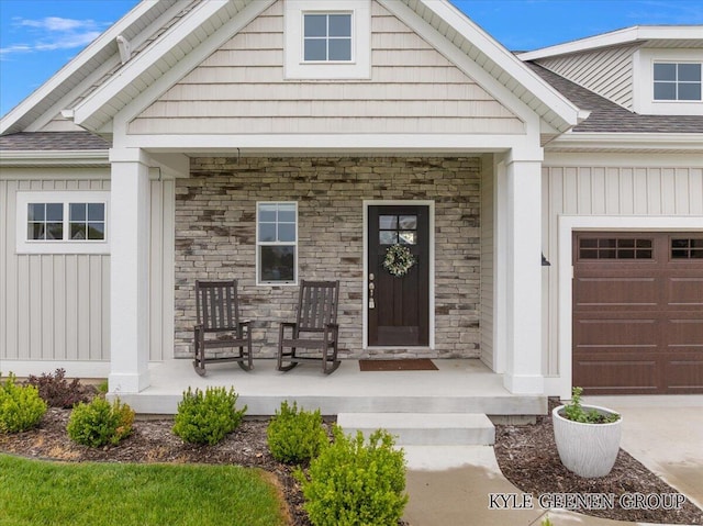 4745 W Lake Dr, Holland, MI 49423 - entrance to property featuring a porch, stone siding, an attached garage, and roof with shingles