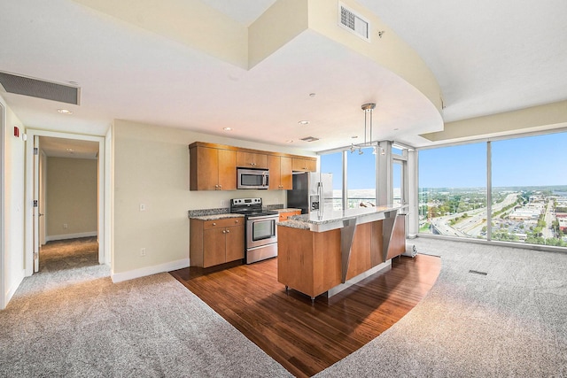 335 Bridge St NW Unit 2005, Grand Rapids, MI 49504 - kitchen featuring appliances with stainless steel finishes, dark colored carpet, brown cabinetry, baseboards, and recessed lighting