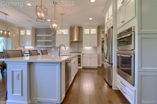 49062 Honey Tree Ct, Northville, MI 48168 - kitchen with wall chimney range hood, a sink, a chandelier, stainless steel appliances, and white cabinetry