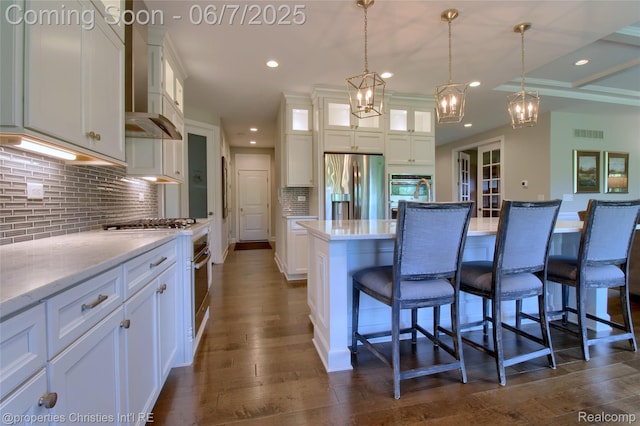 49062 Honey Tree Ct, Northville, MI 48168 - kitchen with appliances with stainless steel finishes, wall chimney range hood, white cabinets, a breakfast bar area, and recessed lighting