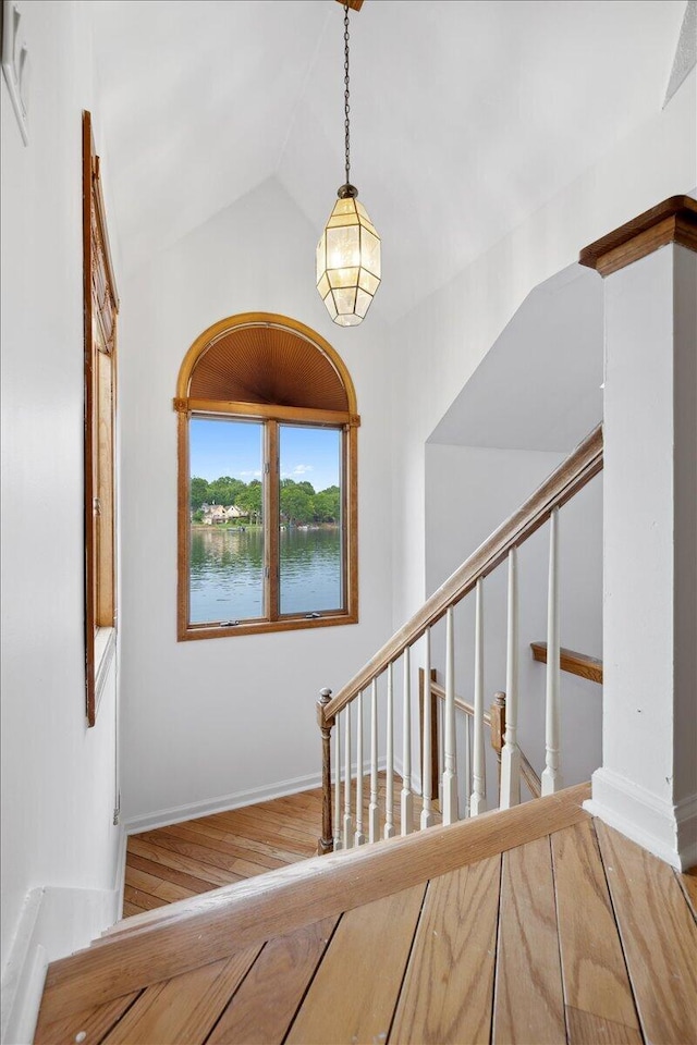 1176 Lakeside Dr, Howell, MI 48843 - stairway featuring wood finished floors, lofted ceiling, and baseboards