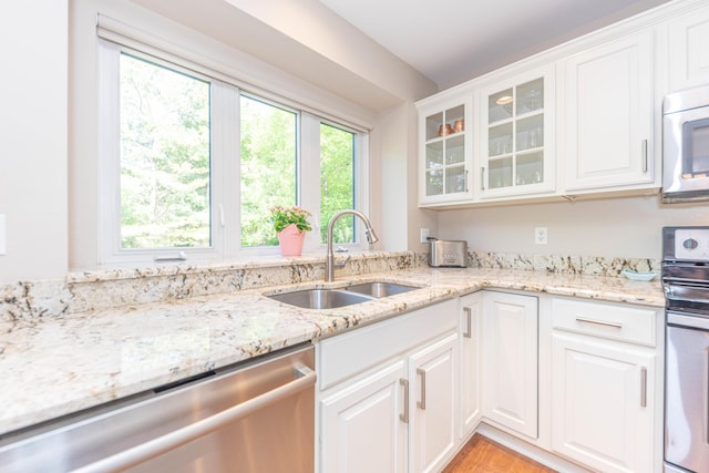 6240 Vineyard Ave, Ann Arbor, MI 48108 - kitchen with stainless steel appliances, a sink, glass insert cabinets, light stone countertops, and white cabinetry