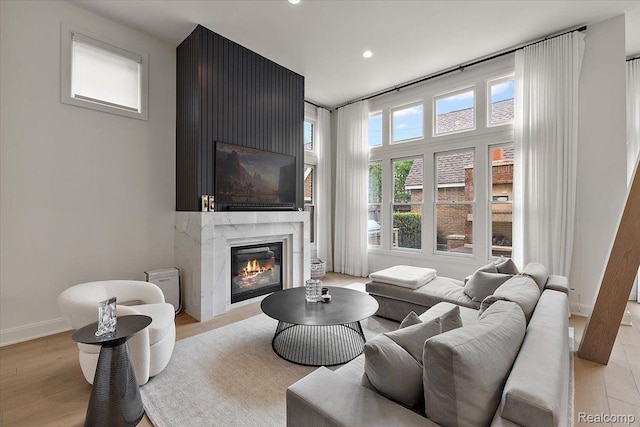 647 Ann St, Birmingham, MI 48009 - living area featuring a premium fireplace, recessed lighting, light wood-style floors, and baseboards