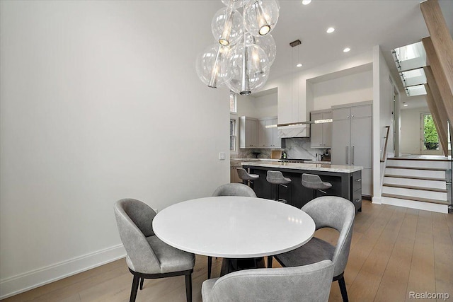 647 Ann St, Birmingham, MI 48009 - dining room featuring a chandelier, baseboards, stairs, wood finished floors, and recessed lighting