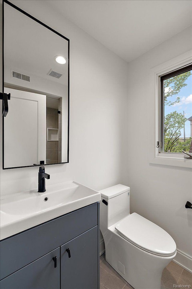 647 Ann St, Birmingham, MI 48009 - bathroom with vanity, toilet, and tile patterned floors