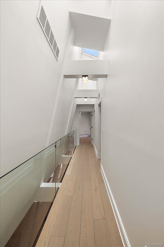 647 Ann St, Birmingham, MI 48009 - hallway with a skylight, hardwood / wood-style floors, and baseboards