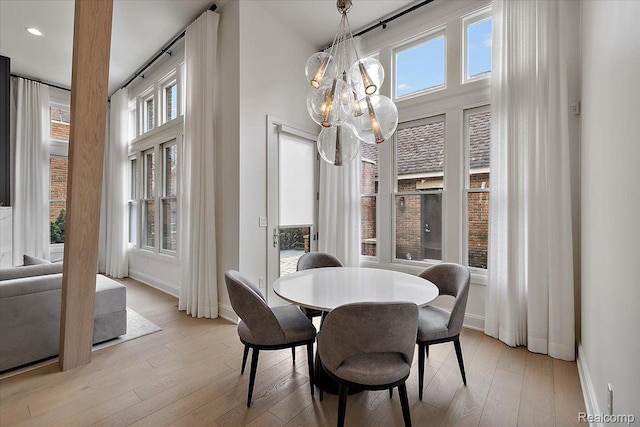 647 Ann St, Birmingham, MI 48009 - dining space with baseboards, healthy amount of natural light, light wood-style flooring, a chandelier, and a high ceiling