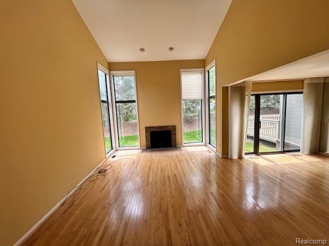 692 Brockmoor Ln, Bloomfield, MI 48304 - unfurnished living room featuring vaulted ceiling, a fireplace with flush hearth, wood finished floors, and baseboards