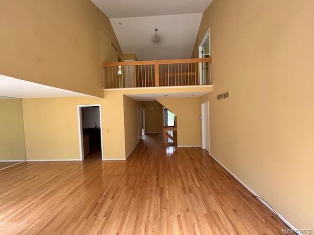 692 Brockmoor Ln, Bloomfield, MI 48304 - unfurnished living room with high vaulted ceiling, wood finished floors, and baseboards