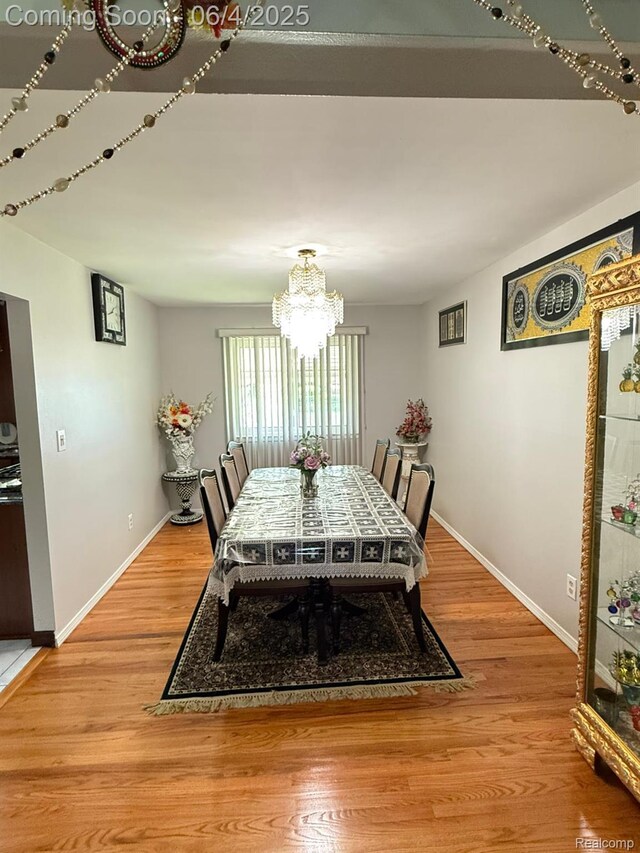 35677 Tina Dr, Warren, MI 48310 - dining area with a chandelier, baseboards, and light wood-style floors