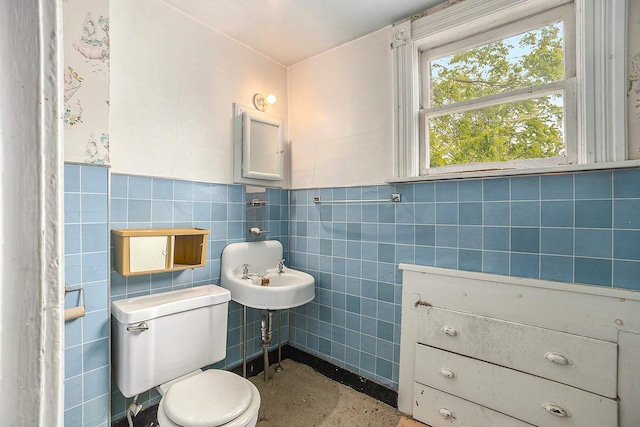 828 Nagold St NW, Grand Rapids, MI 49504 - bathroom featuring toilet, tile walls, and a wainscoted wall