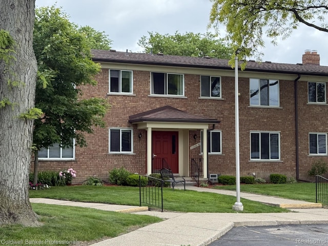 22860 9 Mile Rd Unit 16, Saint Clair Shores, MI 48080 - townhome / multi-family property featuring brick siding, a front lawn, a chimney, and a shingled roof