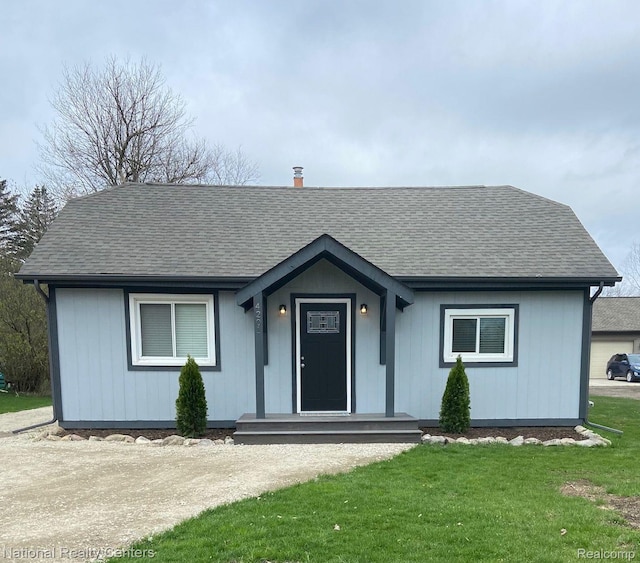 4201 Forest St, Leonard, MI 48367 - view of front of home featuring a shingled roof and a front lawn