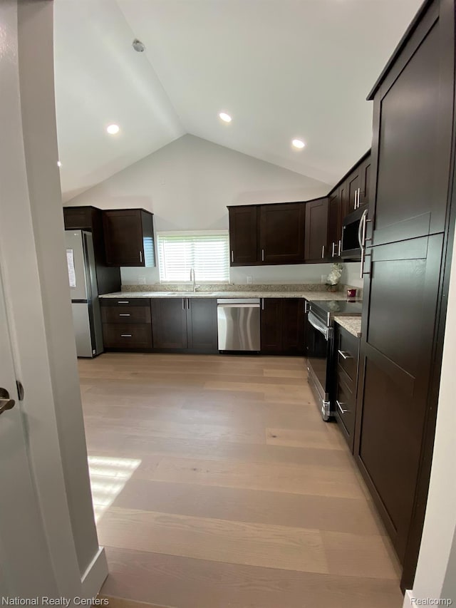 4201 Forest St, Leonard, MI 48367 - kitchen featuring stainless steel appliances, dark brown cabinets, vaulted ceiling, light wood-style floors, and a sink