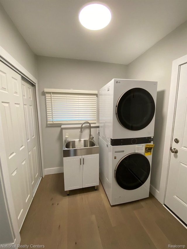 4201 Forest St, Leonard, MI 48367 - laundry room with stacked washer and clothes dryer, cabinet space, dark wood finished floors, and baseboards