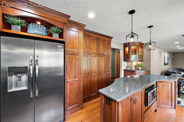 6730 Whiting Dr, Troy, MI 48098 - kitchen featuring appliances with stainless steel finishes, a kitchen island, light wood-type flooring, dark stone countertops, and crown molding
