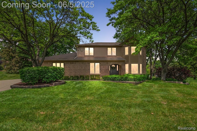 6730 Whiting Dr, Troy, MI 48098 - traditional-style home featuring a front lawn, brick siding, and stucco siding