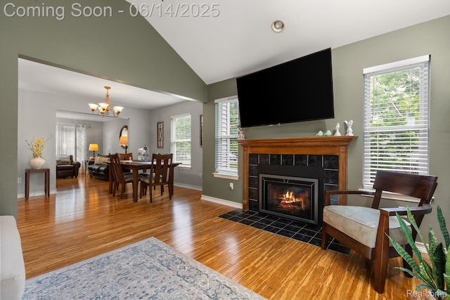 9299 Appleview Ct, Brighton, MI 48116 - living area with wood finished floors, a chandelier, a fireplace, and vaulted ceiling