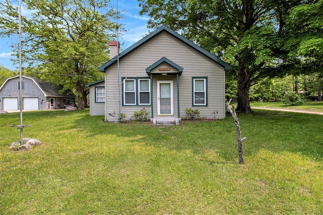 1754 Maggie St, Fountain, MI 49410 - view of front of property with a garage, an outdoor structure, a chimney, and a front lawn