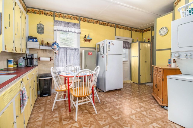 1754 Maggie St, Fountain, MI 49410 - kitchen with freestanding refrigerator, stacked washer / dryer, and light flooring