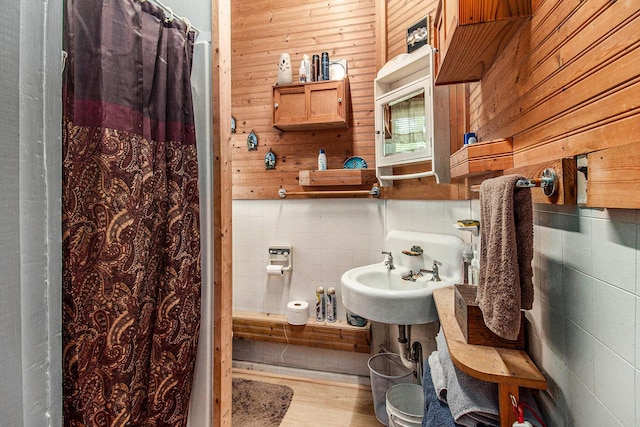 1754 Maggie St, Fountain, MI 49410 - bathroom featuring decorative backsplash, a shower with curtain, tile walls, and wood finished floors