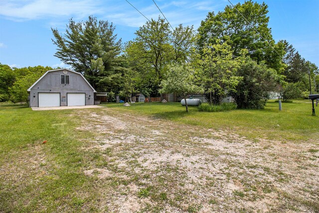 1754 Maggie St, Fountain, MI 49410 - view of green lawn featuring a detached garage, an outbuilding, and view of wooded area