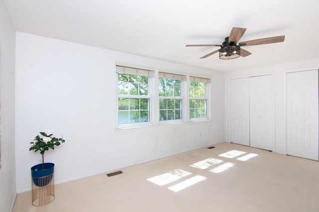 19578 Crystal Lake Dr, Northville, MI 48167 - unfurnished bedroom featuring light colored carpet, two closets, ceiling fan, and baseboards