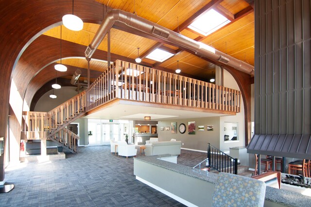 19578 Crystal Lake Dr, Northville, MI 48167 - carpeted living area featuring high vaulted ceiling, stairway, and wooden ceiling