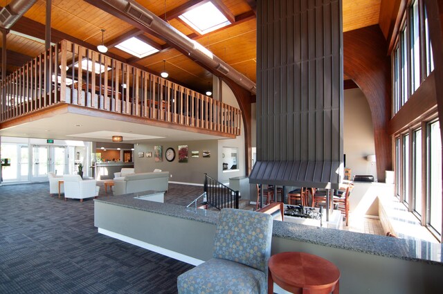 19578 Crystal Lake Dr, Northville, MI 48167 - living room featuring a high ceiling, carpet floors, and wooden ceiling with exposed beams