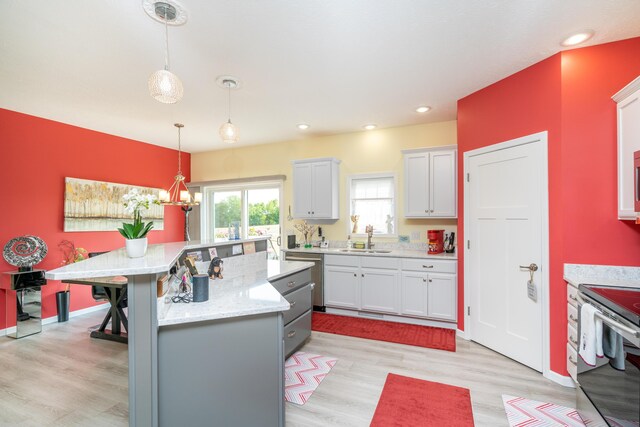 30877 County Road 687, Bangor, MI 49013 - kitchen with a sink, light wood finished floors, pendant lighting, stainless steel appliances, and a kitchen island