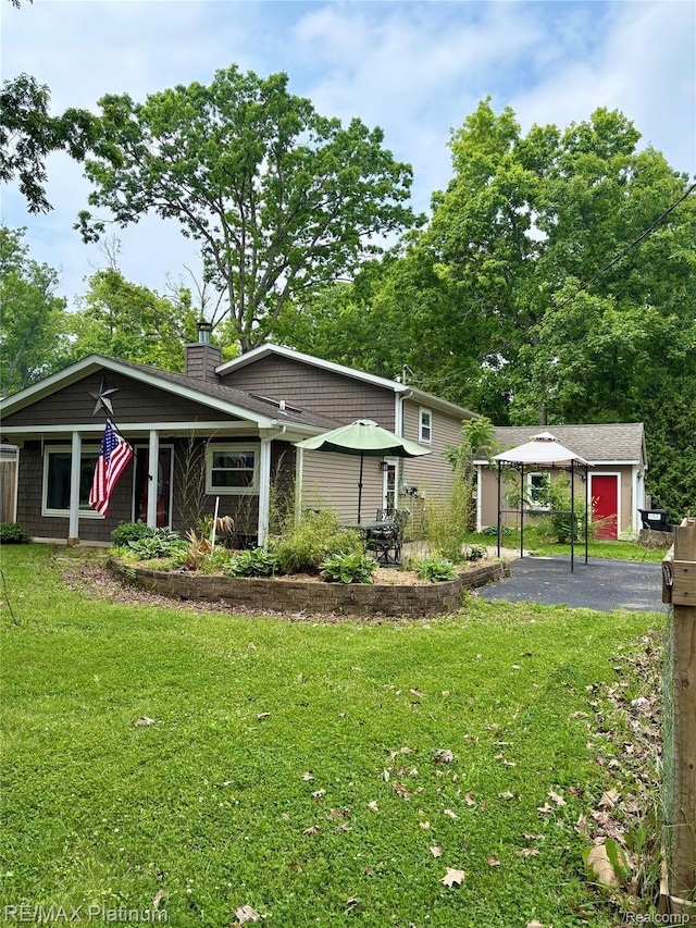 1707 Maxfield Rd, Hartland, MI 48353 - view of front of property featuring a detached carport, a chimney, and a front yard