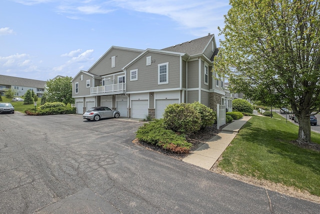 3474 River Run St SW, Wyoming, MI 49418 - view of side of home with a residential view, a lawn, a garage, and stone siding
