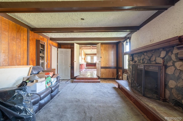 511 N Byfield St, Westland, MI 48185 - living area with wooden walls, beamed ceiling, a stone fireplace, and a textured ceiling